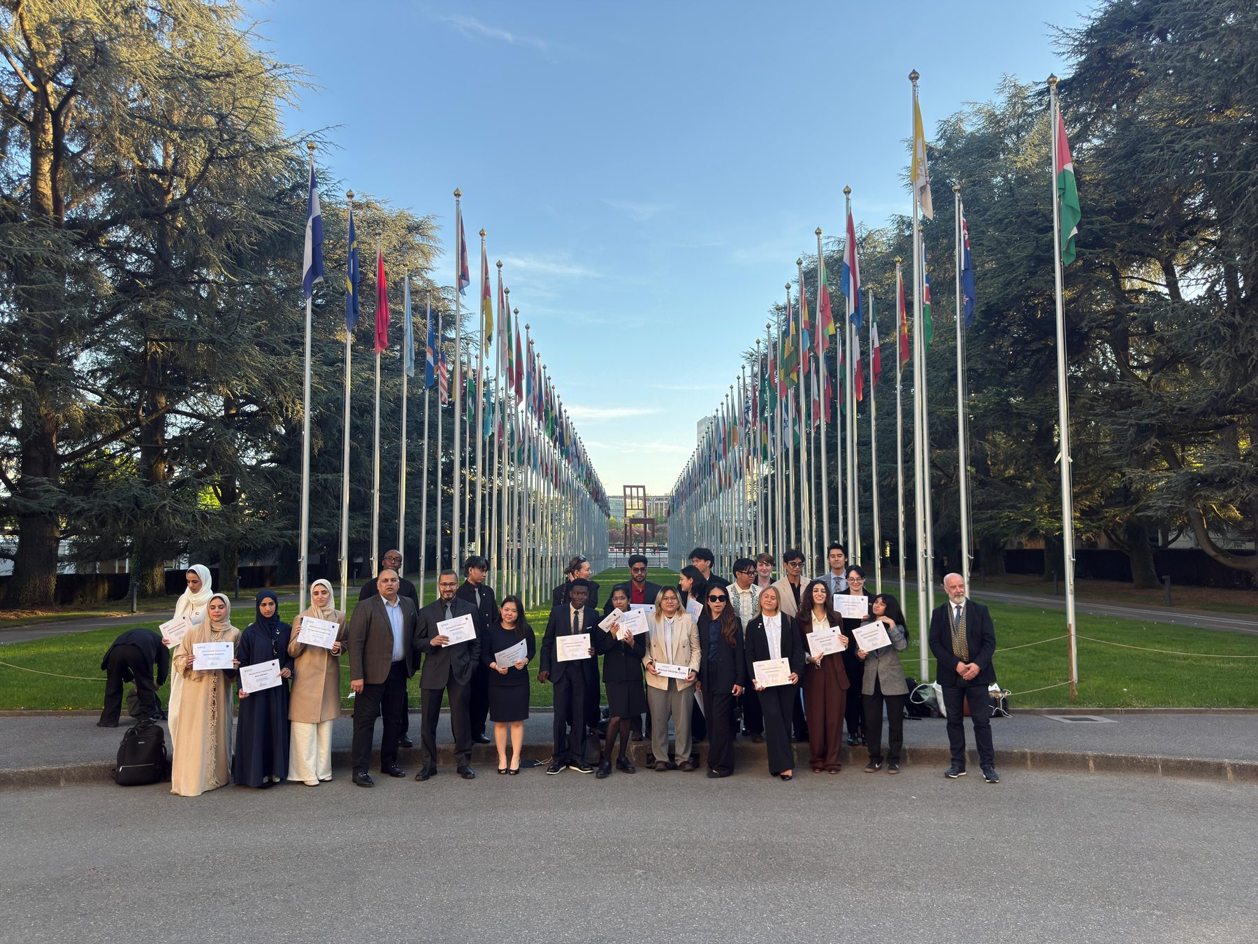 The full international cohort holding certificates at the Allee des Nations, United Nations Geneva